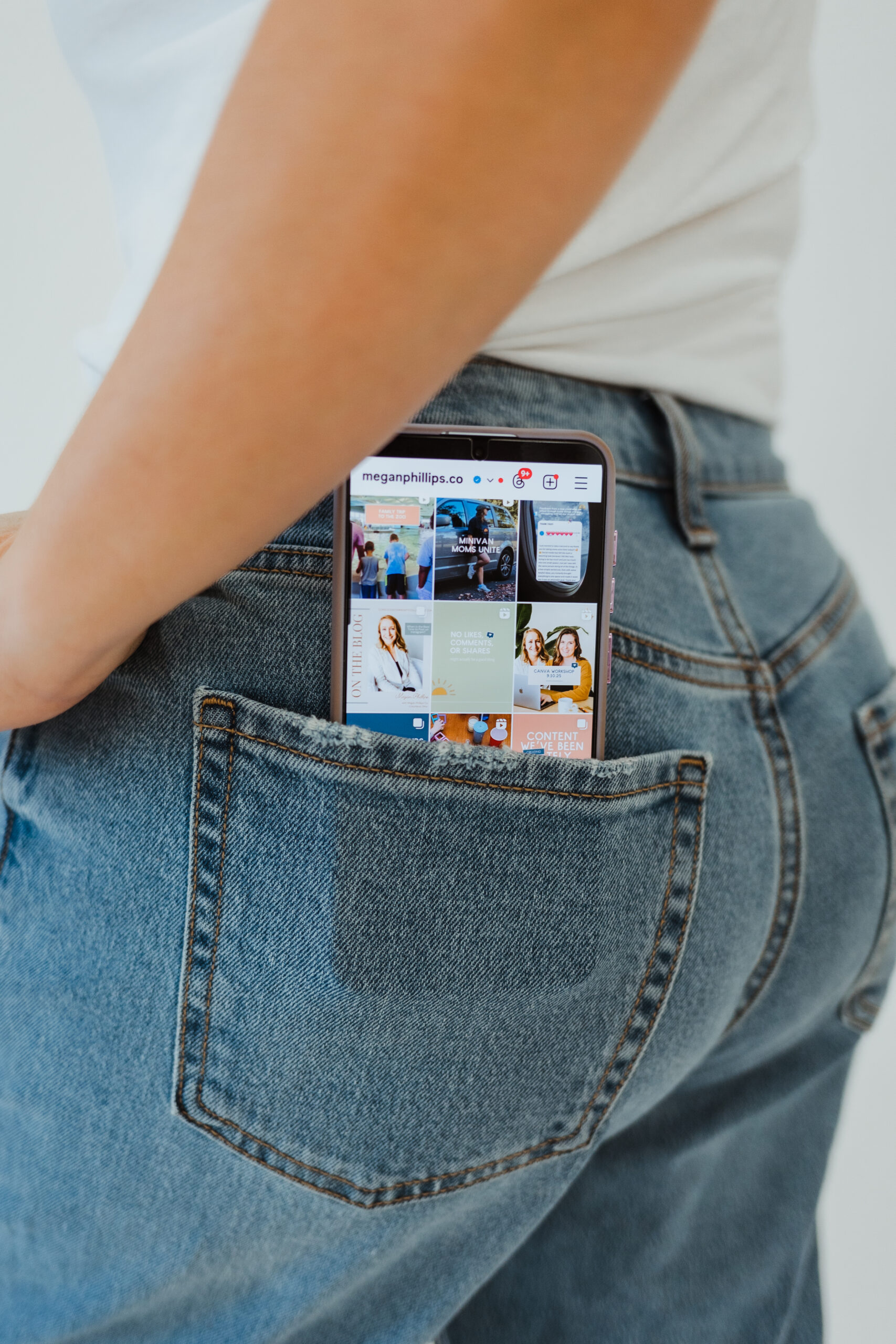 a phone is in a jean back pocket, with instagram shown on the phone